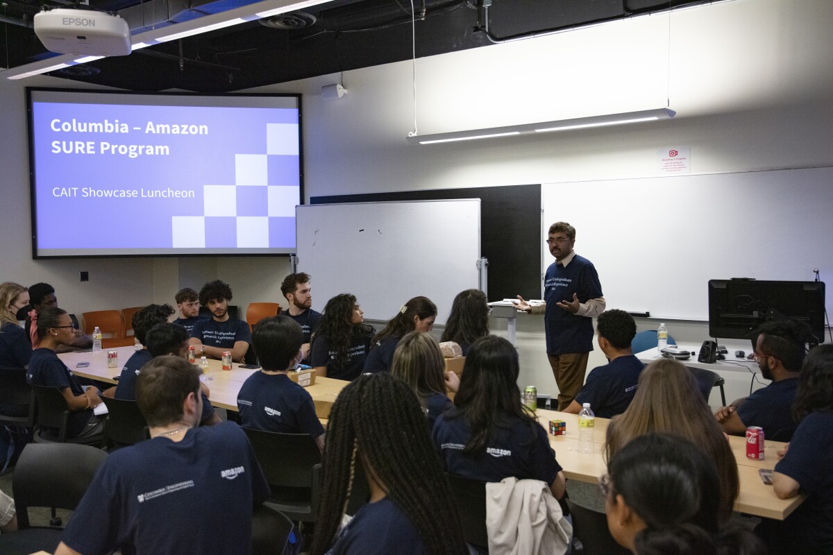 Prem Natarajan is seen standing at the front of a Columbia University classroom, fielding questions SURE students