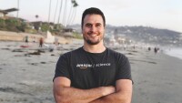 Jared Wilber is seen standing on a beach wearing an Amazon Science t-shirt