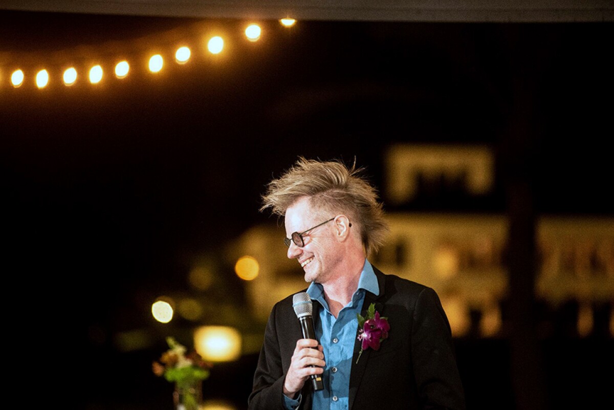 Rustan Leino is seen giving a speech at a wedding, he is holding a microphone and is looking to the side