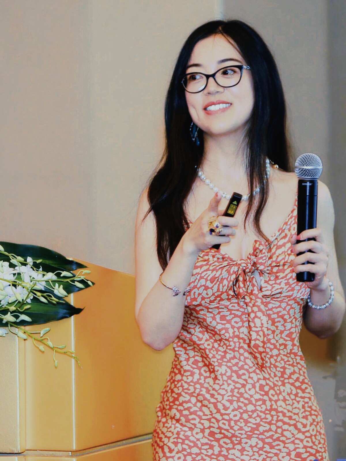 Amazon Scholar and UIUC professor Heng Ji is seen standing, holding a mic while giving a speech