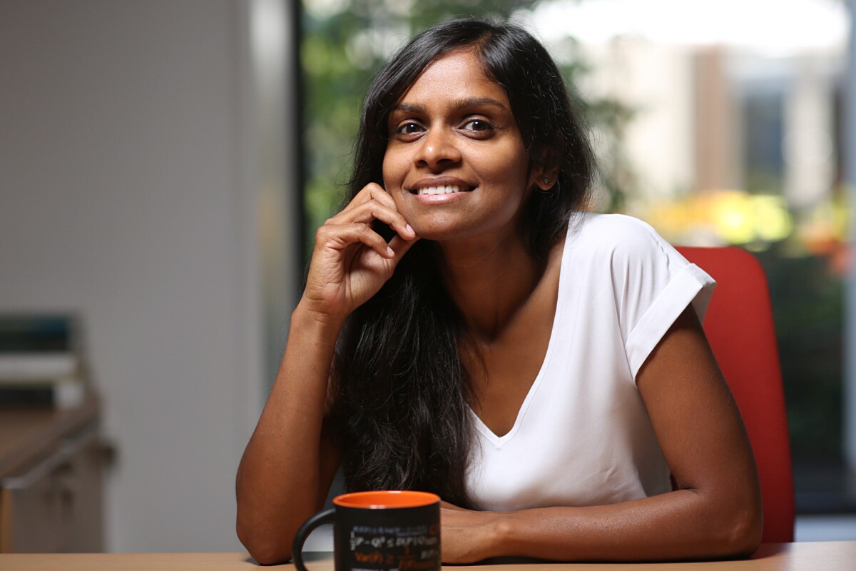 Shipra Agrawal, seated at a desk with a hot beverage