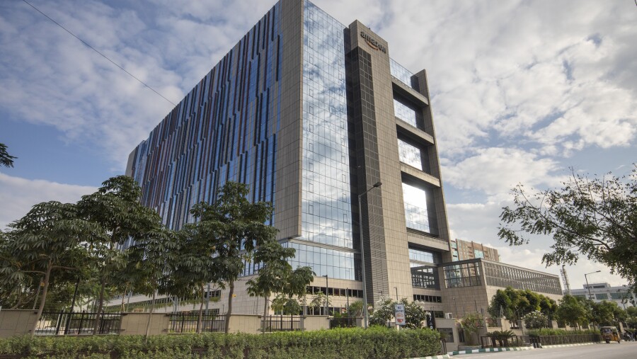 An angled view of the building in Hyderabad, India, featuring shrub-lined streets, trees, and an Amazon sign at the top of the building 