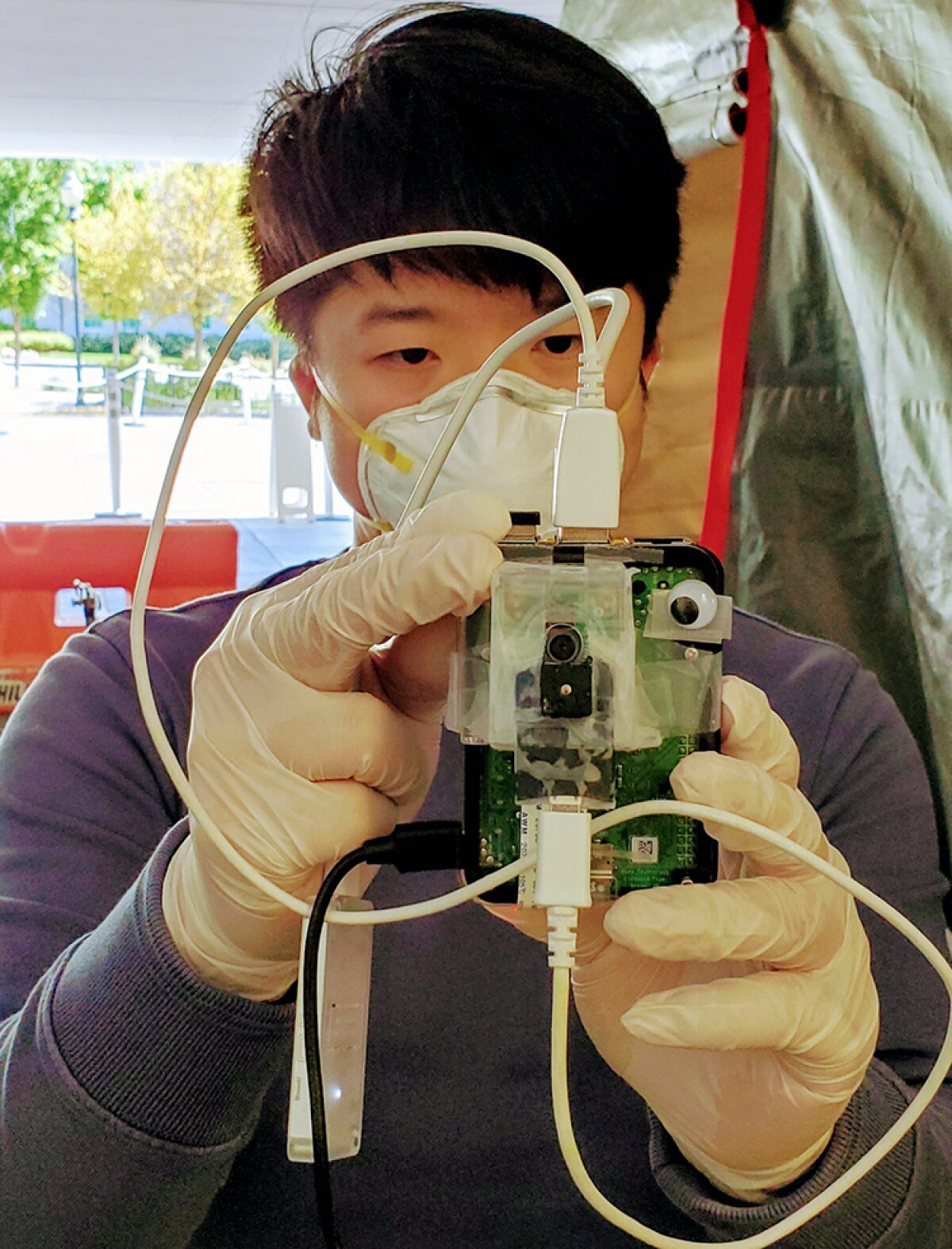 Zifan Jiang, a PhD candidate in machine learning and graduate research assistant at Emory University, is seen here testing a device while wearing sterile gloves and a mask.