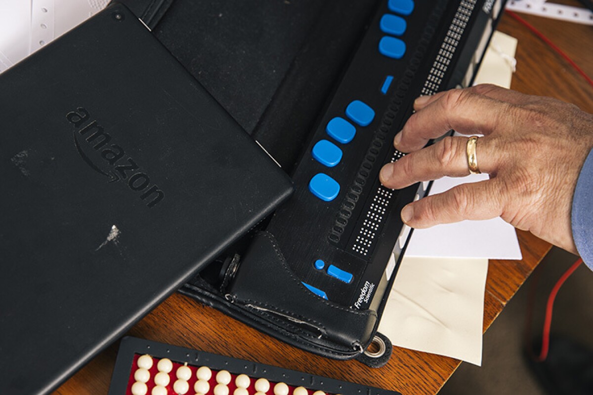 Josh using a refreshable braille display in his home office.jpg