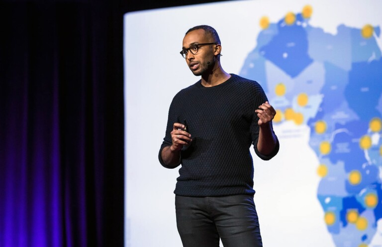 Abdigani Diriye is seen giving a talk in front of a map of the African continent