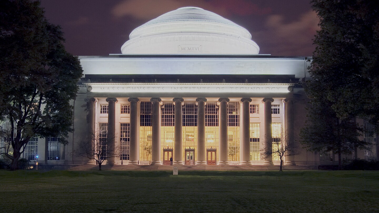 Photo shows a domed MIT campus building at night