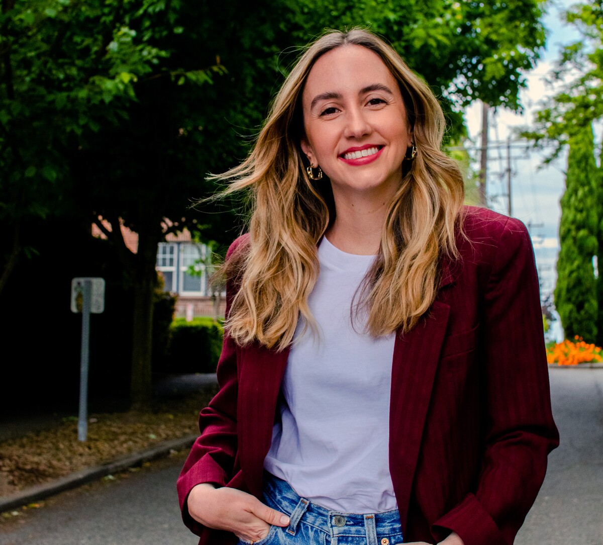 Image shows Cristiana Lara, a research scientist, standing outside and smiling with a tree in the background