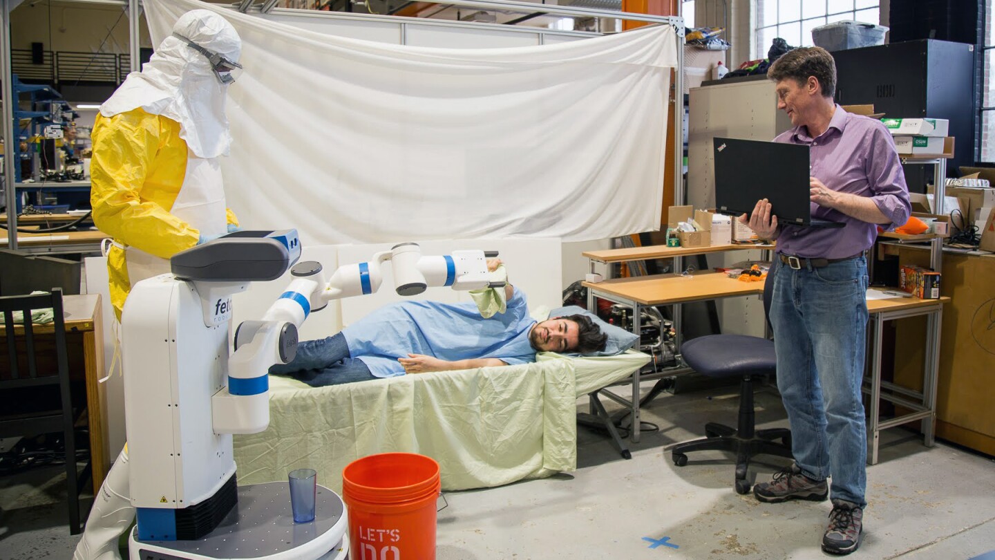 Bill Smart, far right, Oregon State University professor of robotics, and an Amazon Scholar, demonstrates an experiment simulating how robots might be used during Ebola outbreaks.