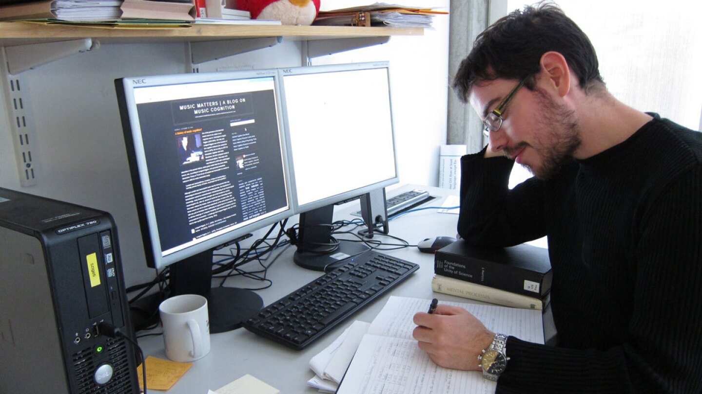 Christos Christodoulopoulos seated at a desk with a computer.