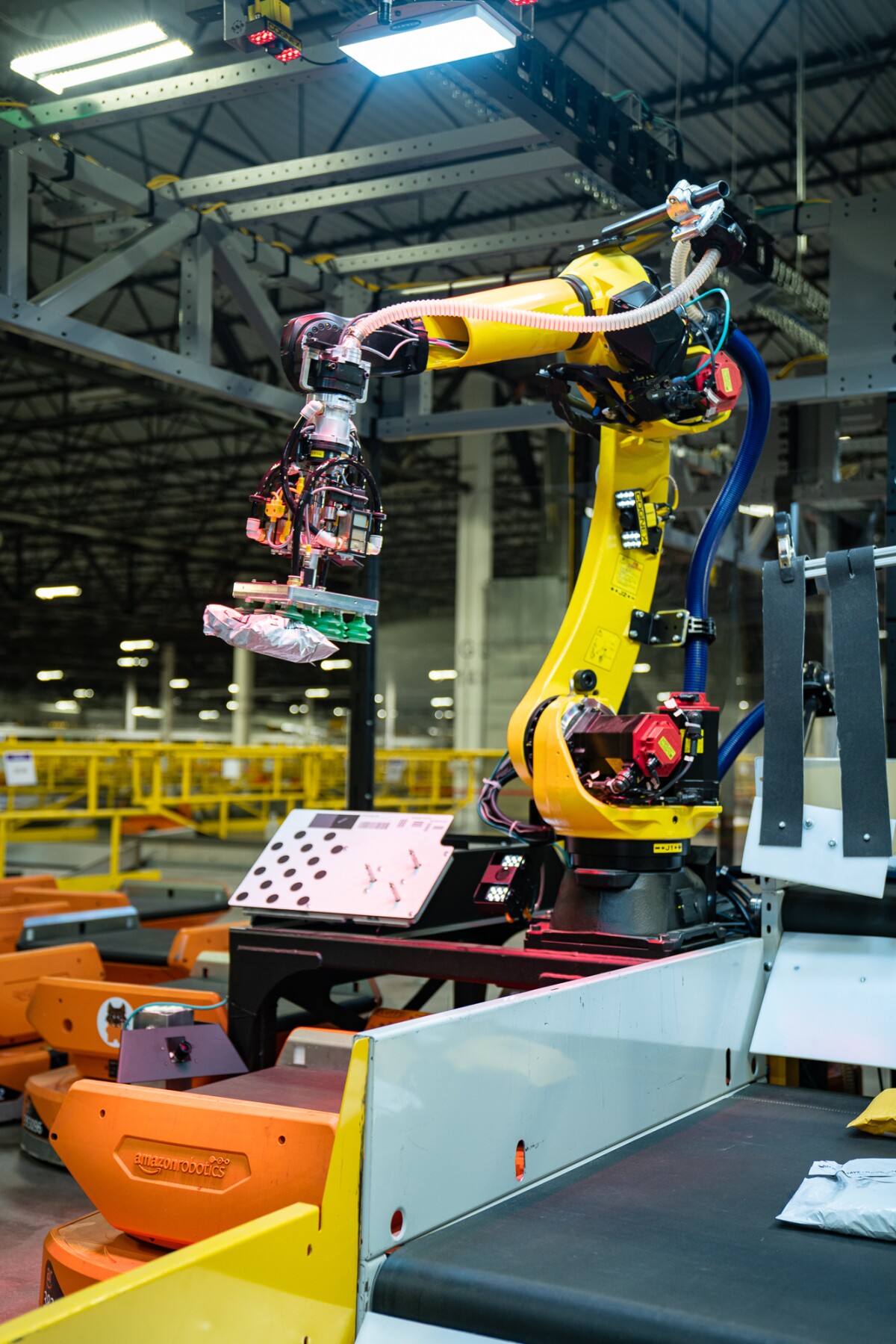 Amazon's Robin robotic arm is seen inside a facility gripping a package