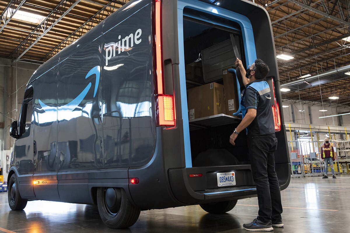 An Amazon employee loads an electric delivery van inside a delivery station in Los Angeles.