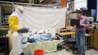 Bill Smart, far right, Oregon State University professor of robotics, and an Amazon Scholar, demonstrates an experiment simulating how robots might be used during Ebola outbreaks.