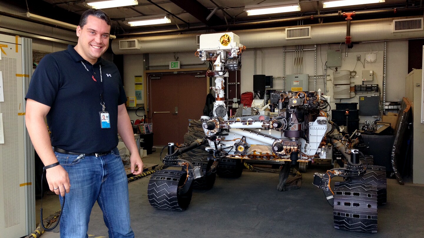 Olivier Toupet is seen standing next to a model of one of the Mars rovers