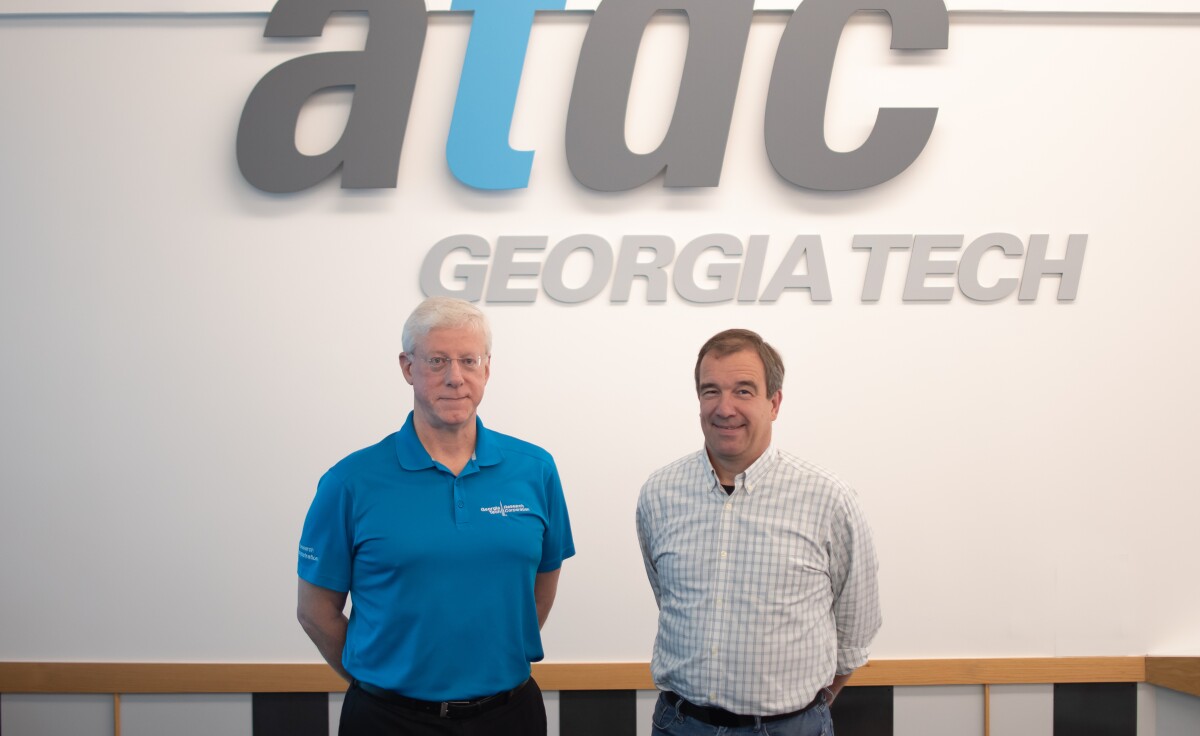 ATDC director John Avery is seen standing next to Thomas Felis, director of robotics strategy for Amazon Global Robotics -- the ATDC Georgia Tech logo is on a wall behind them