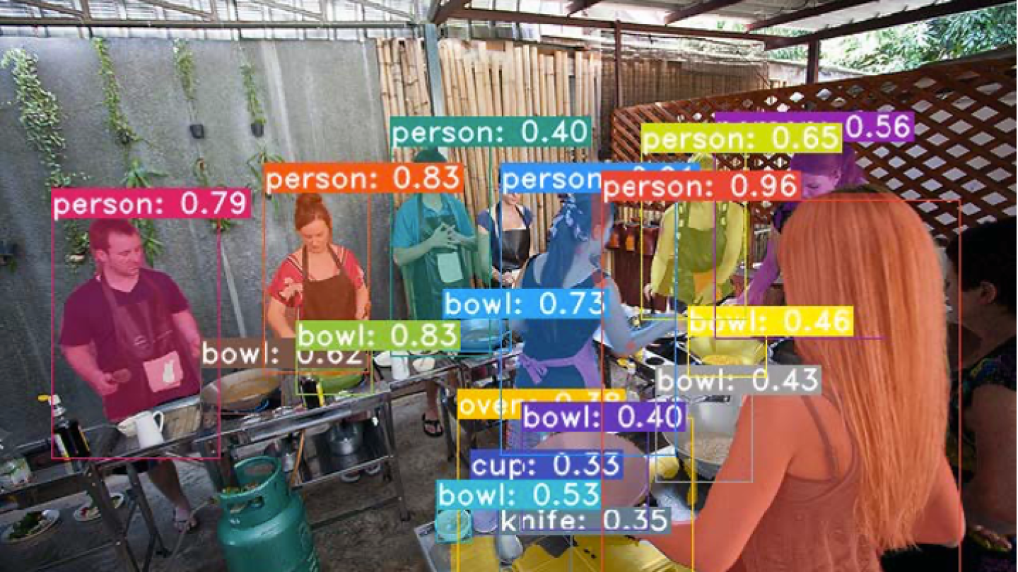 This image is overlaid with graphics and labels showing an example of instance segmentation as it applies to people eating at a barbecue, there are labels for person, bowl, cup, and knife