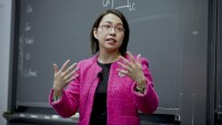 Pai-Ling Yin, senior manager of research science, is seen speaking to a classroom, there is a chalkboard behind her and she is gesturing with her hands.