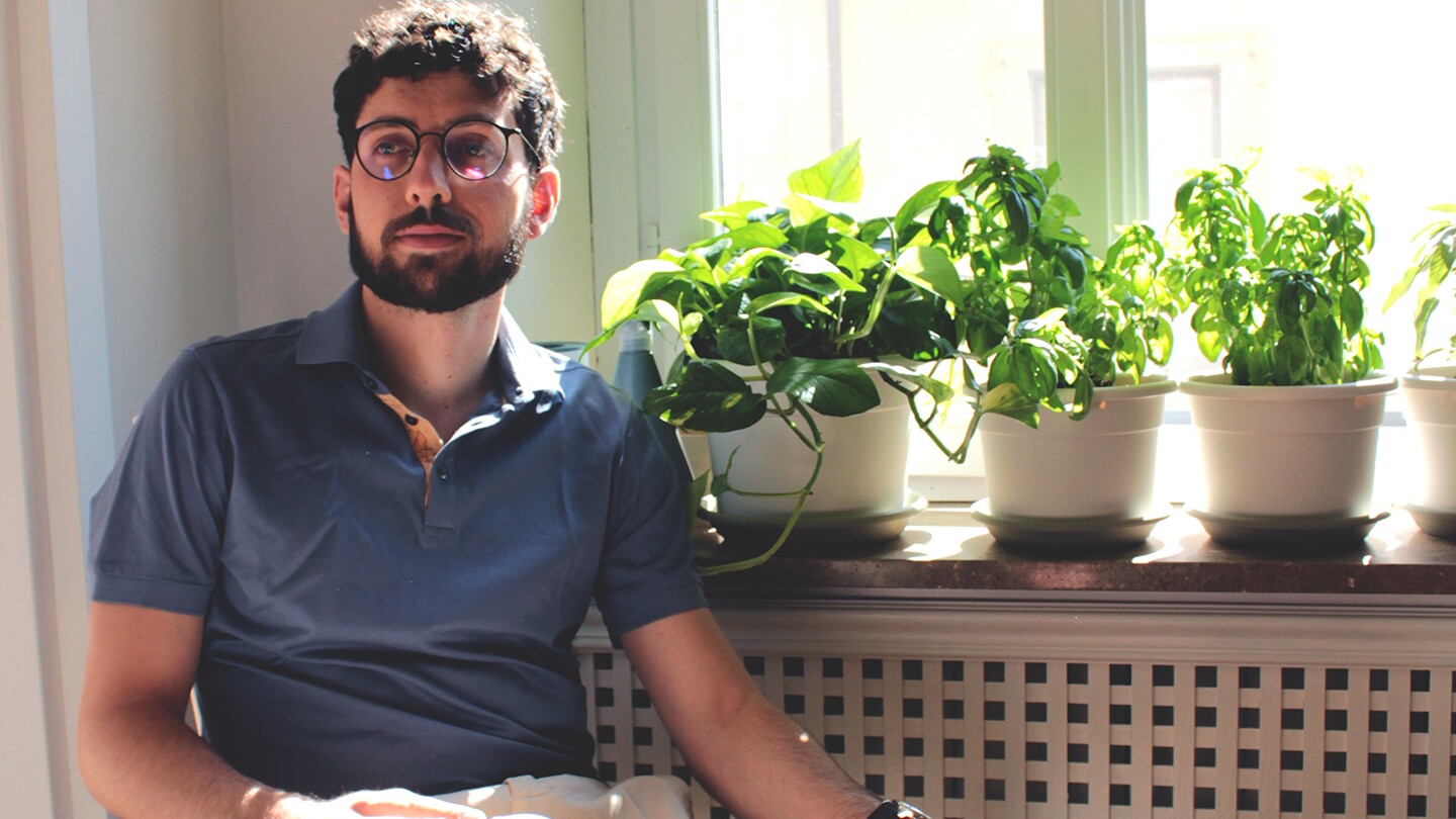 Donato Crisostomi is seen sitting inside with some potted plants in the background